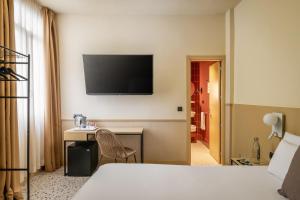 a hotel room with a desk and a television on the wall at BYPILLOW The Citadel in Madrid +27 photos