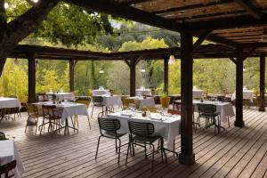 a restaurant with white tables and chairs on a wooden deck at Hotel E Caselle - Demeures & Châteaux in Venaco