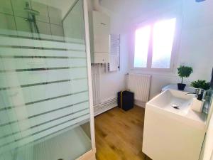 ein Badezimmer mit Waschbecken und Glasdusche in der Unterkunft Emeraude du centre Elbeuf Confort et Elegance in Elbeuf