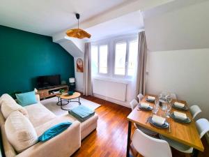 ein Wohnzimmer mit einer weißen Couch und einem Tisch in der Unterkunft Emeraude du centre Elbeuf Confort et Elegance in Elbeuf