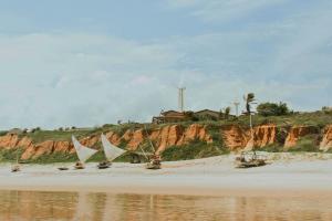 a beach with windmills and nets on the sand at Maré · Casa Maré in Aracati