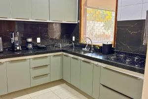 a kitchen with white cabinets and a sink and a stove at Maré · Casa Maré in Aracati