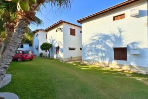 a car parked next to a house with a palm tree at Maré · Casa Maré in Aracati