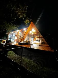 een klein huis wordt 's nachts verlicht bij Idílico Glamping in Barbosa
