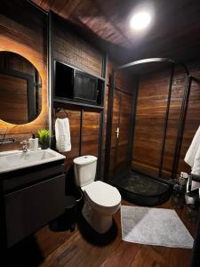 een badkamer met een toilet, een wastafel en een douche bij Idílico Glamping in Barbosa