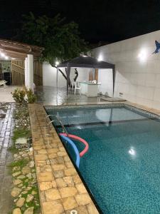 a swimming pool at night with an outdoor swimming pool at Beach House in Barra dos Coqueiros