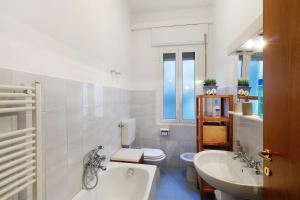 un bagno bianco con lavandino e WC di La casetta di Hiba a Diano Marina Altre 13 foto