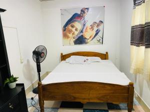 een slaapkamer met een bed en een poster aan de muur bij Dula Guest Home - Tangalle in Tangalle
