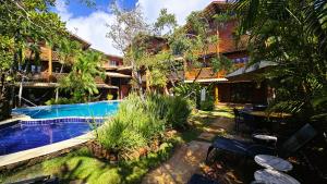 a resort with a swimming pool in front of a building at Pousada Casa do Forte in Praia do Forte