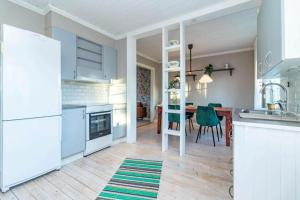 een keuken met witte apparatuur en een tafel met stoelen bij DAL914-Dals-Langed-Dingelvik-Oestra-Mon-30 in Dingelvik