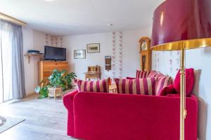 a living room with a red couch and a tv at KAL1031-Boda-Glasbruk-Storgatan-32 in Boda Glasbruk +3 photos