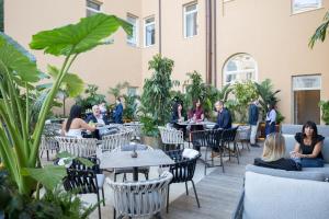 a group of people sitting at tables in a restaurant at Palazzo 4 Fontane 12 in Rome