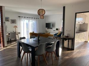 een eetkamer en woonkamer met een tafel en stoelen bij House with Garden in Bombarral - 100 m², Shared Pool in Barrocalvo