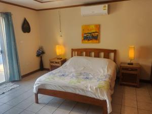 a bedroom with a bed and two night stands with lamps at Villa Baansiesom in Sam Roi Yot +23 photos