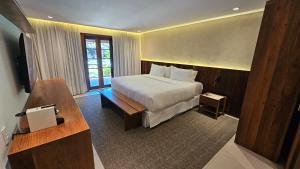 a hotel room with a bed and a desk at Pousada Casa do Forte in Praia do Forte