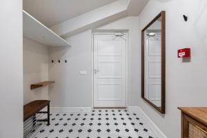 une salle de bain avec une porte blanche et un sol carrelé noir et blanc dans l'établissement T64 apartments by SmartStay, à Tallinn 207 autres photos