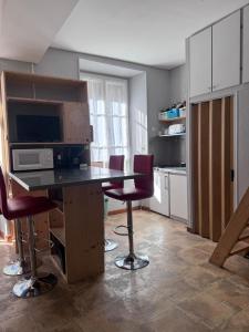 een keuken met een tafel en stoelen in een kamer bij Résidence Le Georgina in Cauterets