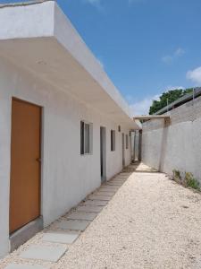 een gang van een wit gebouw met een deur bij Rooms in Cancun Airport in Cancun