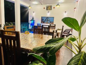 a dining room with a table and chairs and a plant at Shaa Home Stay Sigiriya in Sigiriya