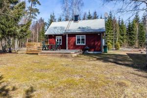 ein rotes winziges Haus mit einer Veranda und einer Terrasse in der Unterkunft KRO958 Hamneda - Torsgård 2 in Traryd