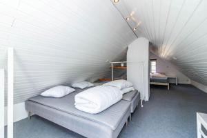 Zimmer mit 4 Betten und weißen Kissen in der Unterkunft KRO958 Hamneda - Torsgård 2 in Traryd