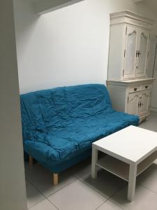 un divano blu in un soggiorno con un tavolo di Studio a Eysines