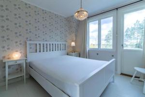 una camera bianca con un letto bianco e un lampadario a braccio di JON830-Mariannelund-Hornsved-1 a Ingatorp