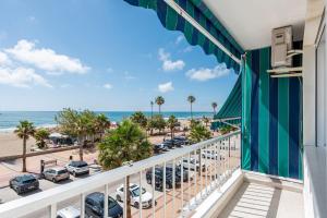 a balcony with a view of the beach and parking lot at RgHost-Apartamento España en Paseo Marítimo in Málaga