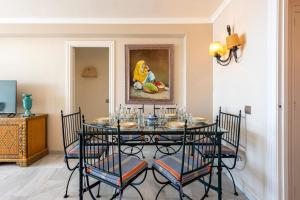 a dining room with a table with chairs and a painting at RgHost-Apartamento España en Paseo Marítimo in Málaga
