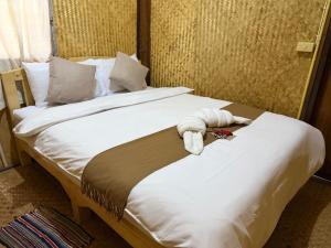 a bed with a stuffed animal on top of it at Hometown Pai Boutique Bungalow in Pai +33 photos