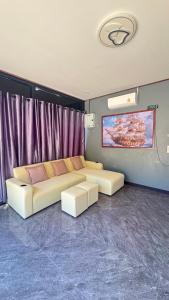 a living room with two white couches in a room at Relax sunsmile Kohyaonoi in Ko Yao Noi