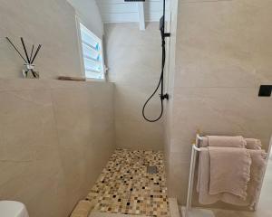 a bathroom with a shower with a tile floor at Tropical moon in Saint Martin +6 photos