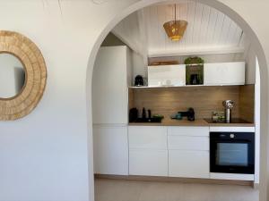 a kitchen with white cabinets and an archway at Tropical moon in Saint Martin