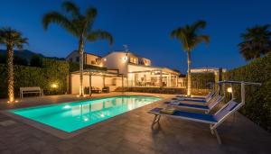 ein Haus mit einem Pool und Palmen in der Unterkunft Villa Dell'Ulivo con piscina privata By Sicily Home Solutions in Alcamo
