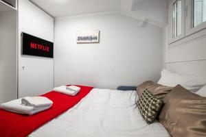 une chambre avec un lit avec une couverture rouge dans l'établissement Le Coq Chiron - AC - Wi-Fi - Monaco border, à Monte-Carlo
