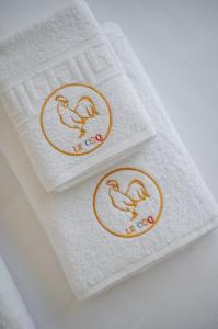 deux serviettes avec une serviette à motif d'oiseau. dans l'établissement Le Coq Chiron - AC - Wi-Fi - Monaco border, à Monte-Carlo