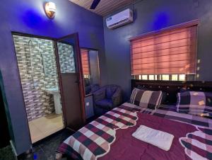 een slaapkamer met een bed, een spiegel en een wastafel bij JEVENOM HOTEL in Ibafo