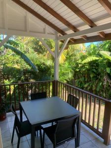 a porch with a table and chairs on a balcony at BRADA gites in Deshaies