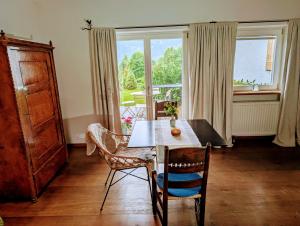 een eetkamer met een tafel en stoelen en een raam bij Studio Murnauer Moos in Murnau am Staffelsee
