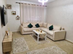 a living room with a couch and a table at santa barbara in Mansouria
