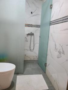 a bathroom with a toilet and a glass shower door at santa barbara in Mansouria +10 photos