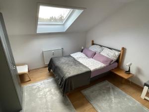 a bedroom with a bed with purple sheets and a window at Ferienwohnung I&I in Halsenbach