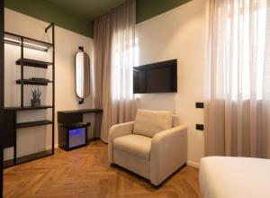 a living room with a chair and a television at Jrose Hotel in Jerusalem
