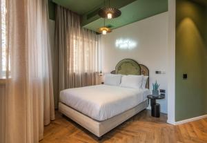 a bedroom with a large bed with white sheets at Jrose Hotel in Jerusalem +37 photos