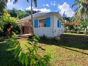 een klein huisje met blauwe luiken op een erf bij La Kaz Kako in Sainte-Rose