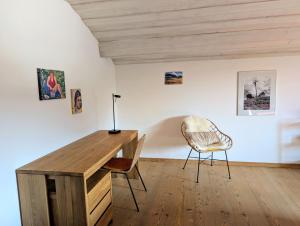 a room with a wooden desk and two chairs at Ferienwohnung Murnauer Moos in Murnau am Staffelsee