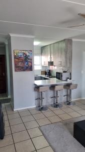 una cucina con un bancone e sgabelli in una stanza di Riley's Place a Cape Town