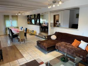 a living room with a couch and a dining room at Ferienwohnung I&I in Halsenbach