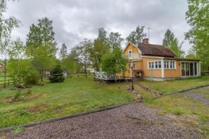 a small yellow house with a large yard at KAL911-Hjorted-Sandekulla in Gissebo
