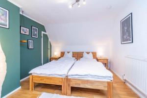 a bedroom with a bed with white sheets and green walls at KAL911-Hjorted-Sandekulla in Gissebo